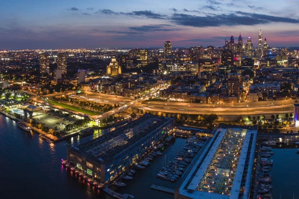 Philadelpia Downtown at sunset. The view from the Benjamin Franklin Bridge over the piers in Old City and Delaware River. Pennsylvania, USA.