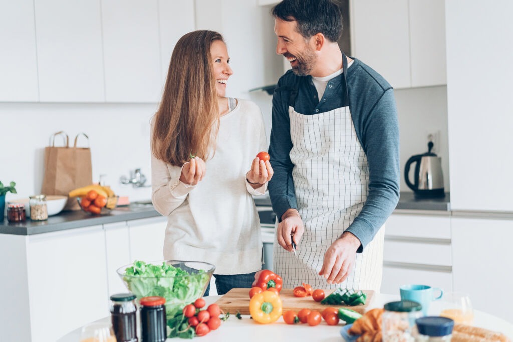 Happy middle aged couple preparing food together