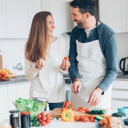 Happy middle aged couple preparing food together