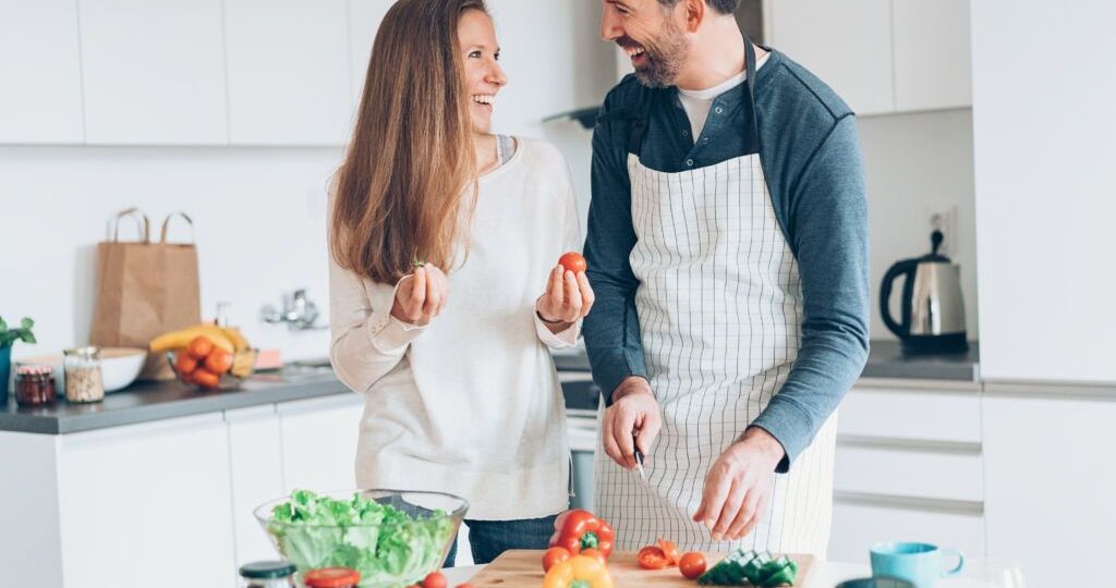 Happy middle aged couple preparing food together