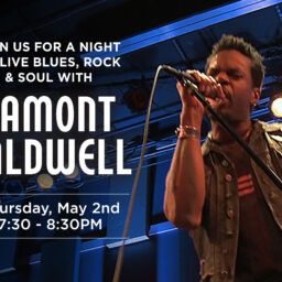 Lamont Caldwell singing on blue light stage.