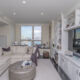 Spacious living area with built in white cabinets and bookshelves and large windows overlooking Philadelphia's Delaware River