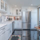 Stunning open kitchen with white cabinetry, stainless steel appliances, and sliding glass door with Philadelphia skyline