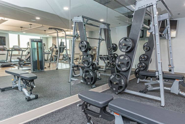 Free weights with large mirror in spacious condominium fitness center