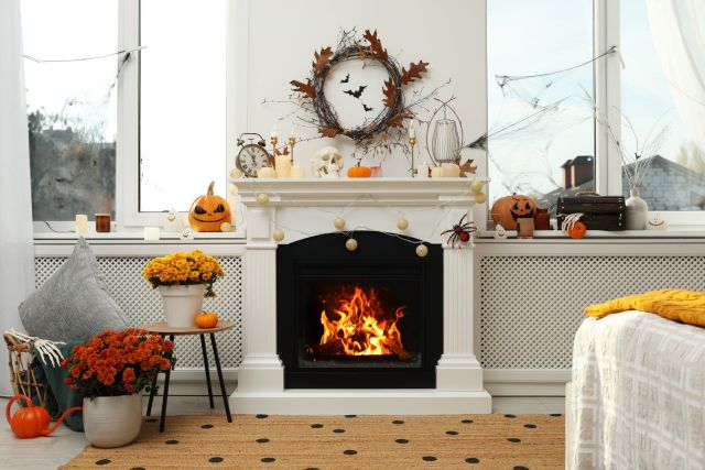 Modern room with fireplace decorated for Halloween. Festive interior