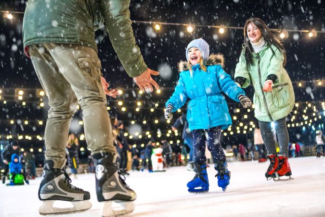 Parent with daughter ice skating